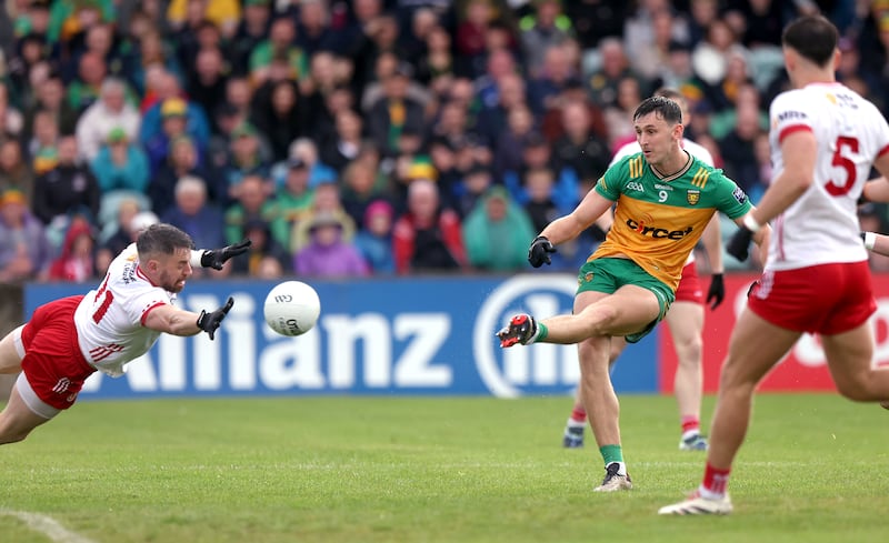 Tyrone's Mattie Donnelly attempts to block a kick from Donegal's Michael Langan. Photograph: John McVitty/Inpho