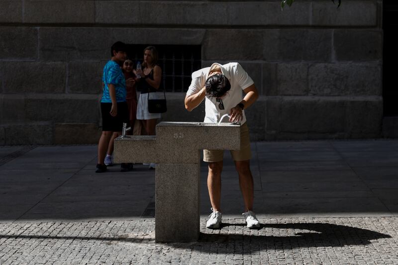 A man cools off with water from a fountain next to Puerta del Sol Square. Photograph: Pablo Blazquez Dominguez/Getty Images