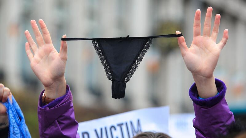 A woman holds up a thong during a protest at the Spire on O’Connell Street in Dublin over victim blaming in the courts. Photograph: Gareth Chaney/Collins.