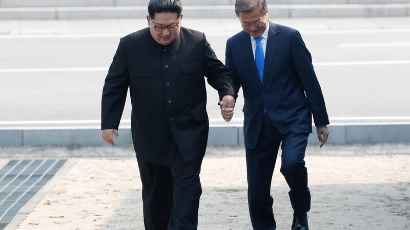 Kim Jong-un, North Korea’s leader and Moon Jae-in, South Korea’s president, hold hands as they cross the Military Demarcation Line  to the southern side of the border at the village of Panmunjom. Photograph: Inter-Korean Summit Press Corps/Pool via Bloomberg