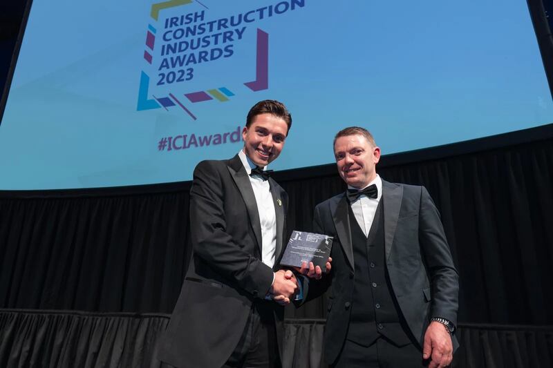 Brandon Panther, technical sales and specifications manager at KCC Group, presents the contractor tourism and hospitality project of the year award to Conor McMahon, Flynn