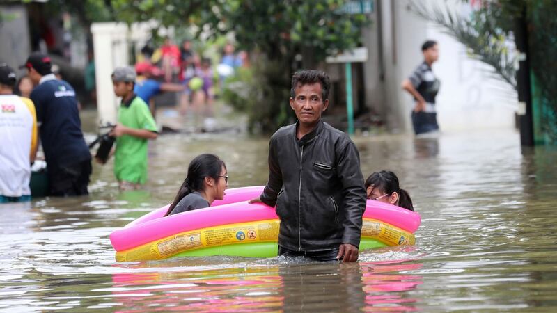 Residents wade through a flooded neighbourhood in Tanggerang on the outskirts of Jakarta, January 2nd, 2020. Photograph: AP Photo/Tatan Syuflana