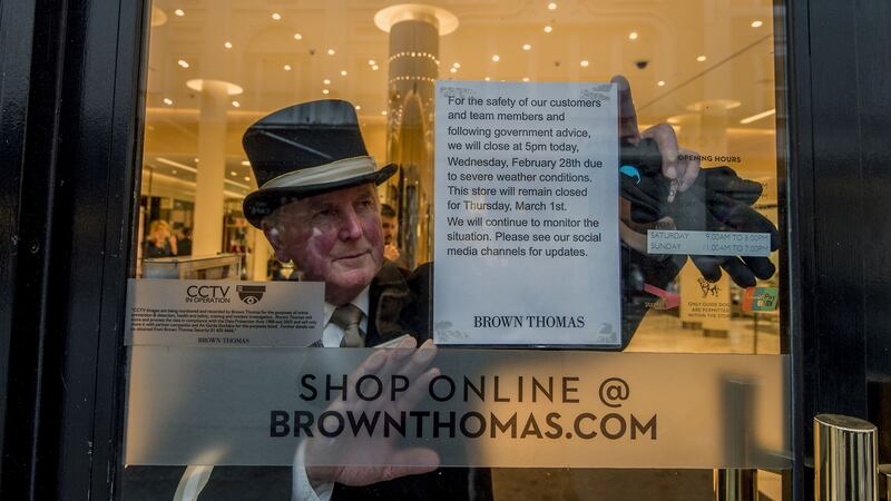 Jim Kearnes, concierge with Brown Thomas, puts a sign up   announcing the stores closure for a couple of days due to adverse weather. Photograph: Brenda Fitzsimons