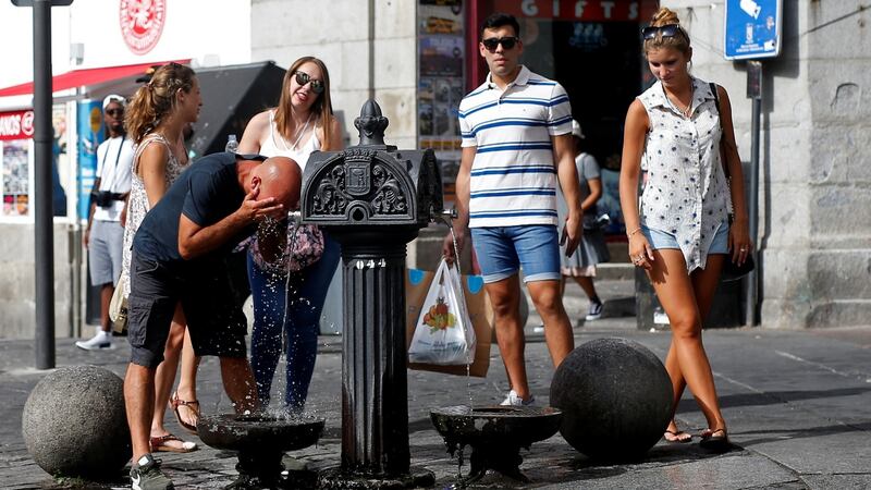 A tourist quenches his thirst at water from a public fountain, in Madrid. Photograph: Javier Barbancho