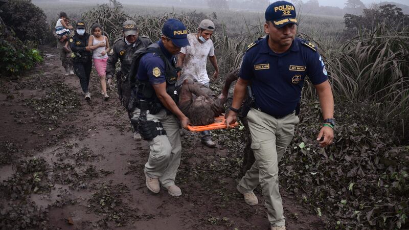 Police  carry a wounded man after the eruption of the Fuego Volcano. Photograph: Getty