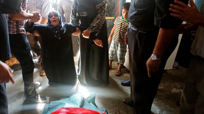 The mother of Palestinian militant Mahmoud Abbas, who medics said was killed by an Israeli air strike, mourns next to his body during his funeral in Gaza City on Sunday. Photograph: Suhaib Salem/Reuters