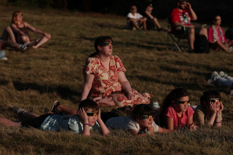 People wear eclipse glasses to watch the eclipse at Dunsink Observatory. Photo: Clodagh Kilcoyne for The Irish Times
