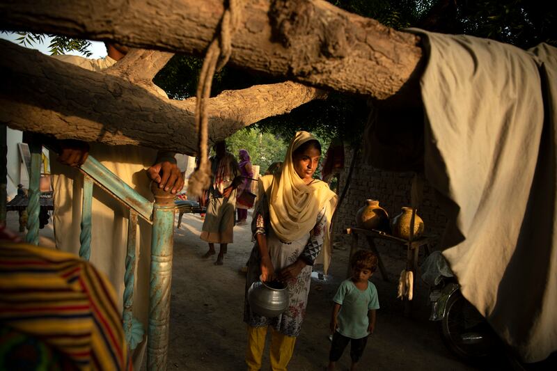 A woman carries water from the only functioning pump in the village of Wado Khosa, Pakistan.  Photograph: Kiana Hayeri/The New York Times