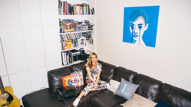 Laura Whitmore in her Camden flat, with her painting of Audrey Hepburn by  graffiti artist Pure Evil.