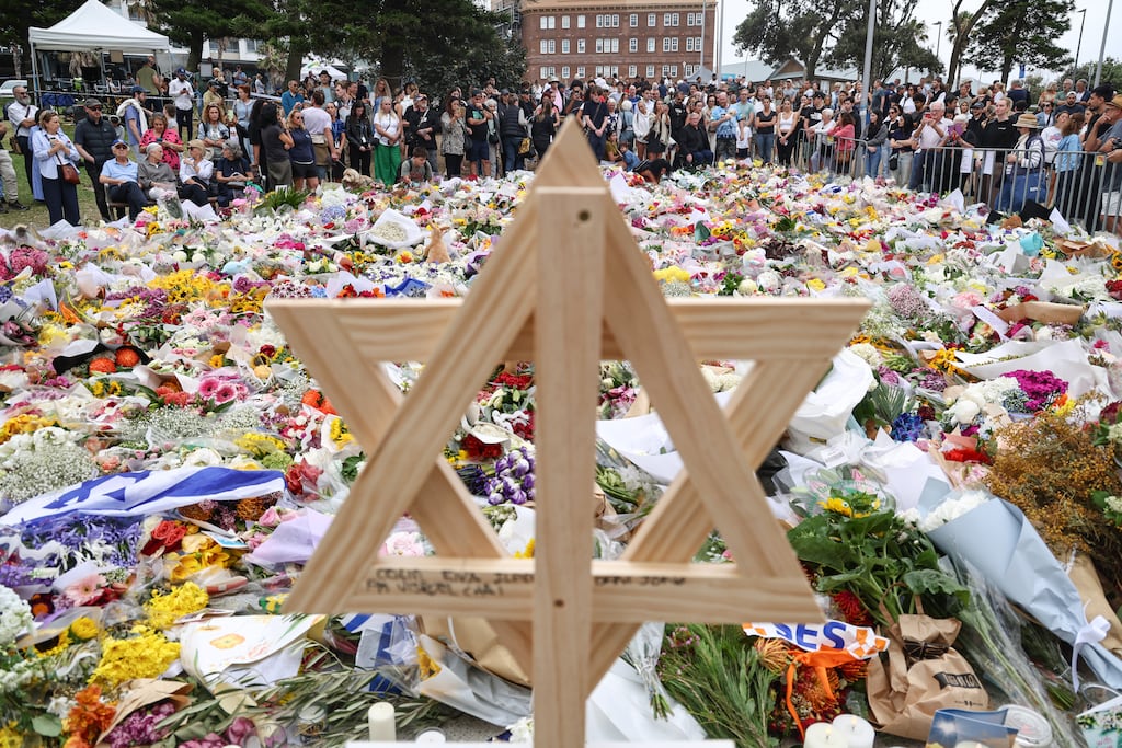 A wooden Star of David is seen as people gather around floral tributes outside Bondi Pavilion in Sydney. Photograph: David Gray/AFP