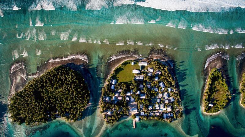 An overhead view of Ejit, center, with the ocean to the north and a lagoon to the south, of the Marshall Islands, where  rising sea levels are already an inescapable part of daily life. (Photograph: Josh Haner/The New York Times)