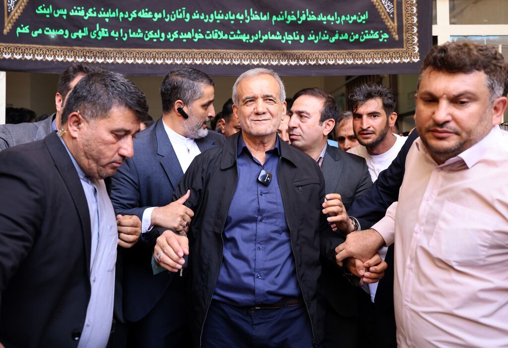 Masoud Pezeshkian (C) is escorted after casting his vote at a polling station during the presidential election in Ghaleh Hasan Khan, Iran. Photograph: EPA