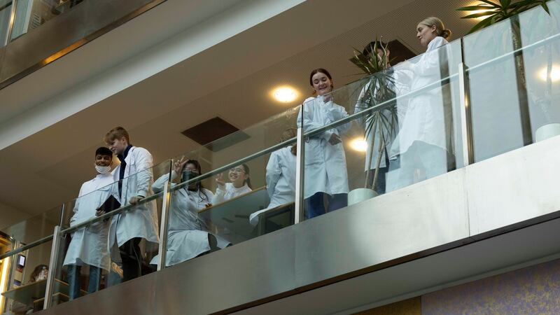 Students at the Trinity Biomedical Sciences Institute in  Pearse Street, Dublin, look on  as Taoiseach Micheál Martin makes his announcement. Photograph: Alan Betson