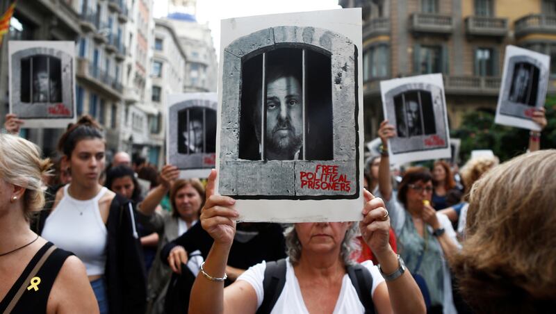 FACE OF SEDITION: A protester holds aloft an image of former Catalan vice-president Oriol Junqueras, mocked up behind bars, as hundreds of people blocked the central Via Laietana in Barcelona, Catalonia, Spain, demonstrating against prison sentences announced for Catalan pro-independence leaders. The Supreme Court condemned Mr Junqueras to 13 years in jail for sedition. Photograph: Quique Garcia/EPA