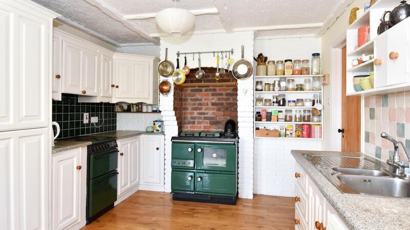The  kitchen/diningroom has a green Stanley range in a brick-lined alcove.