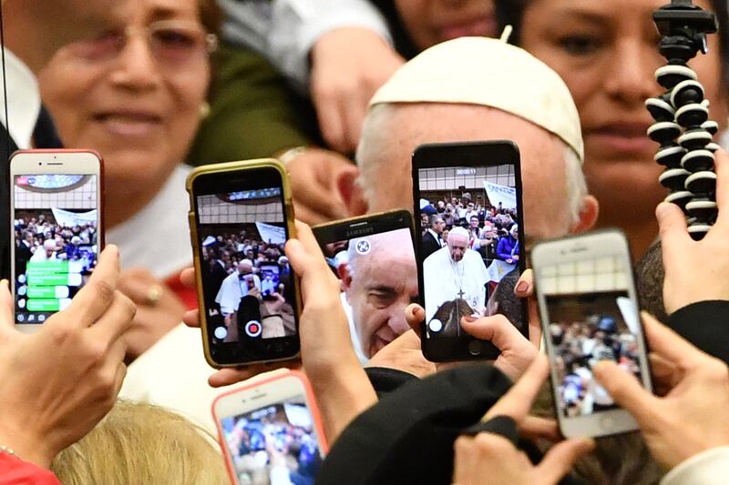 The faithful greet Pope Francis and take photos of him with their mobile phone upon his arrival for the weekly general audience on January 9th, 2019. Photo by ANDREAS SOLARO/AFP via Getty Images