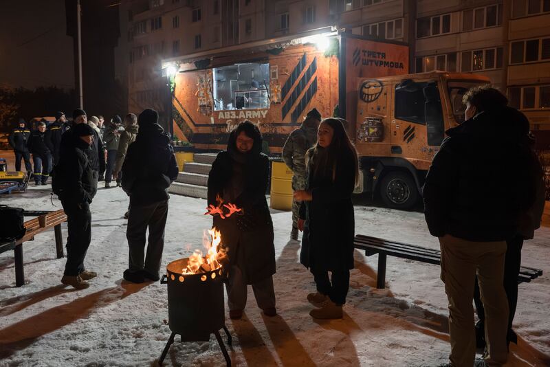 Residents gather around a fire at a mobile kitchen in Kyiv which provides food and warmth to those left without power or heat following Russian strikes on the city's critical infrastructure. Photograph: EPA