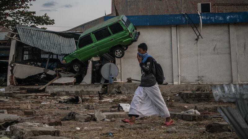 A man walks past a car wedged into a building by the tsunami in Palu, Indonesia. Photograph: Carl Court/Getty Images