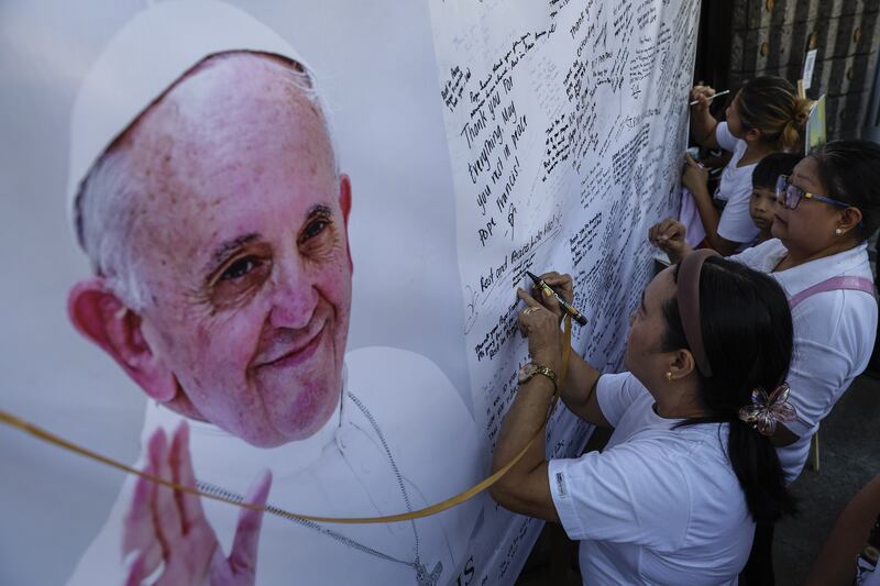Parishioners write on a message board for the late Pope Francis outside the St Peter Parish church in Quezon City. Photograph: Rolex Dela Pena/EPA