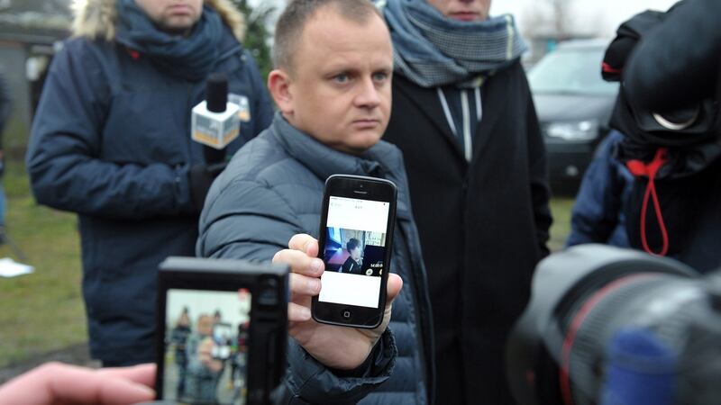 Ariel Zurawski, the owner of a Polish trucking company, shows the last photo of his cousin and driver, Lukasz Urban, apparently the first victim of the attack in Berlin. Photograph: Marcin Bielecki