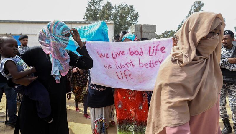 Migrants hold a placard at Ain Zara detention centre for migrants in the Libyan capital Tripoli. Photograph: Mahmud Turkia/AFP via Getty Images