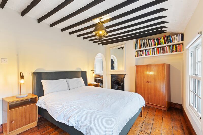 Main bedroom with walk-in wardrobe and cast-iron fireplace. Photograph: Viv van der Holst