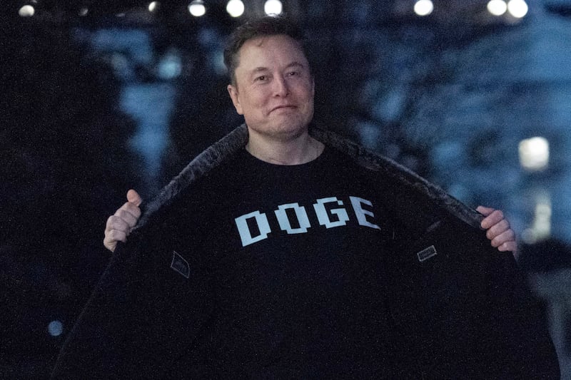 Elon Musk displays a T-shirt reading 'DOGE' to the media as he walks on the South Lawn of the White House in March. Photograph: Jose Luis Magana/AP