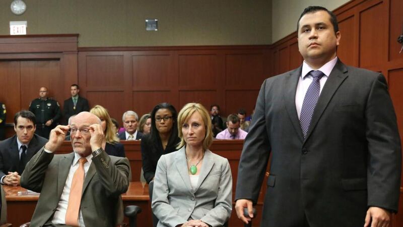 George Zimmerman stands when the jury arrives to deliver the verdict in his murder trial as his attorneys  Don West and Lorna Truett await the announcement. Photograph: Joe Burbank/Reuters.