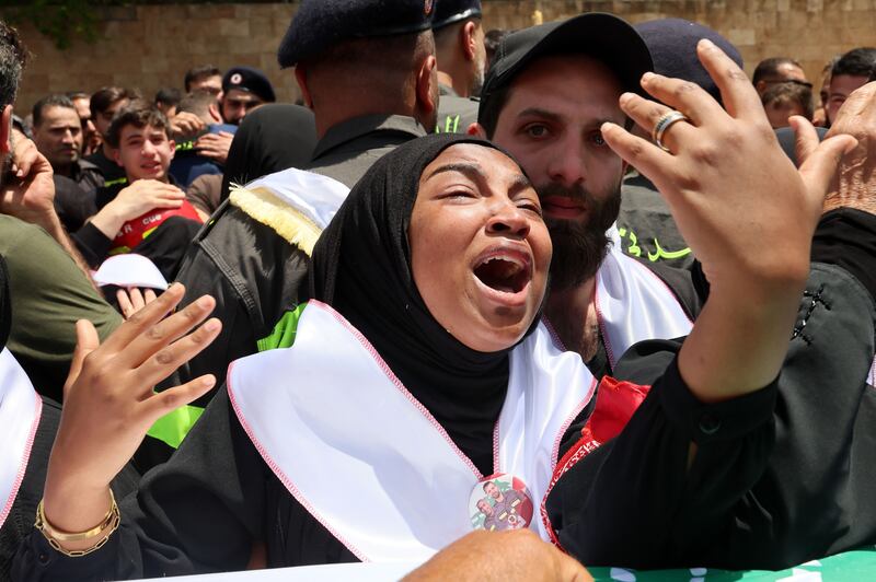 A mourner grieves over the coffin of one of two members of the Lebanese Civil Defense during a funeral procession in Sidon, Lebanon. Photograph: EPA