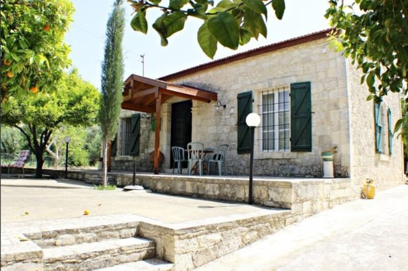 Cyprus: stone house built in 1930, with fruit trees and solar panels in the garden
