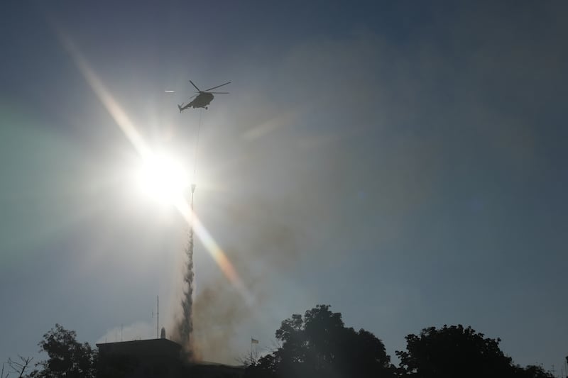 A firefighter helicopter drops water as smoke rises over the government headquarters in Kyiv. Photograph: OLEKSII FILIPPOV/AFP via Getty Images