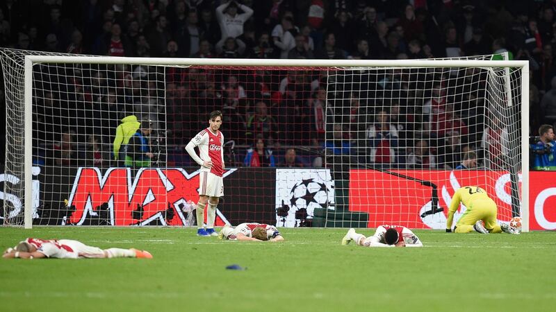 Ajax players fall to the ground after the third goal. Photo: John Thys/Getty Images