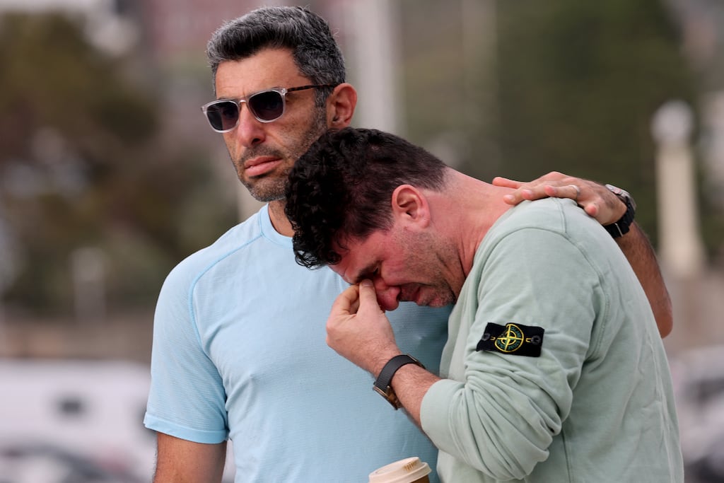 Visitors mourn as they arrive at Bondi Beach in Sydney on December 15, 2025, a day after a shooting at the popular seaside spot. Photo by DAVID GRAY / AFP via Getty Images