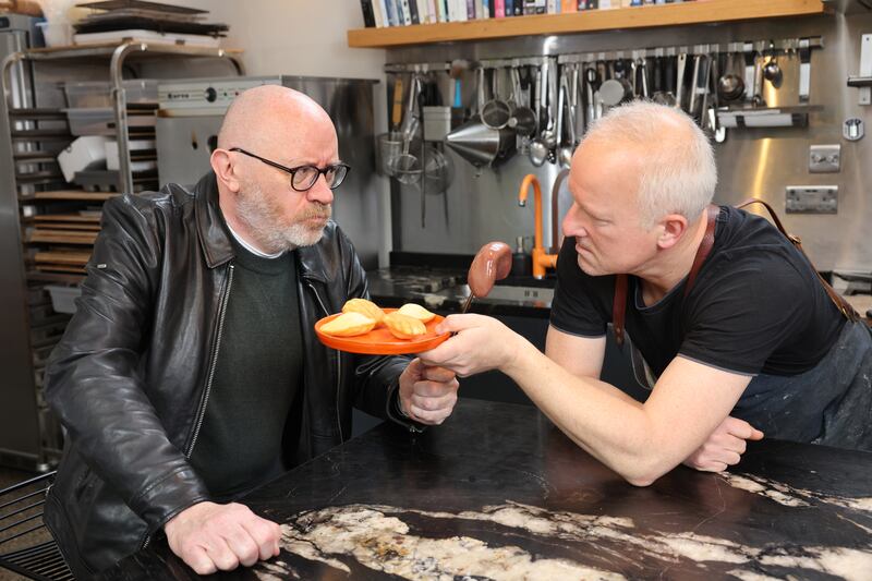 Irish Times film correspondent Donald Clarke and arts promoter turned baker Gerry Godley in Gerry's kitchen in Dublin, with Madeleines and kidney. Photograph: Dara Mac Dónaill 

