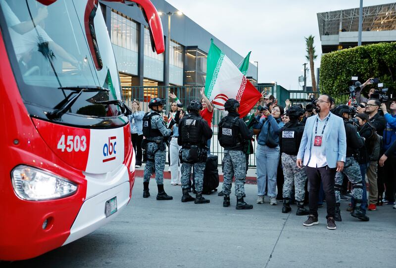 Soccer fans wave as the Iranian national soccer team departs on a bus from Tijuana International Airport. Photograph: Mario Tama/Getty