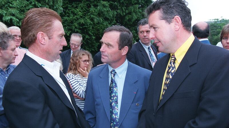 Sean Kelly, left, and Stephen Roche, right, talk with five-times Tour de France winner Bernard Hinault at a wreath-laying ceremony on the grave of Shay Elliott in Kilmacanaogue, Co Wicklow
