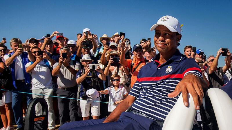 Fans watch on as Tiger Woods passes by in a buggy. Photo: Oisin Keniry/Inpho