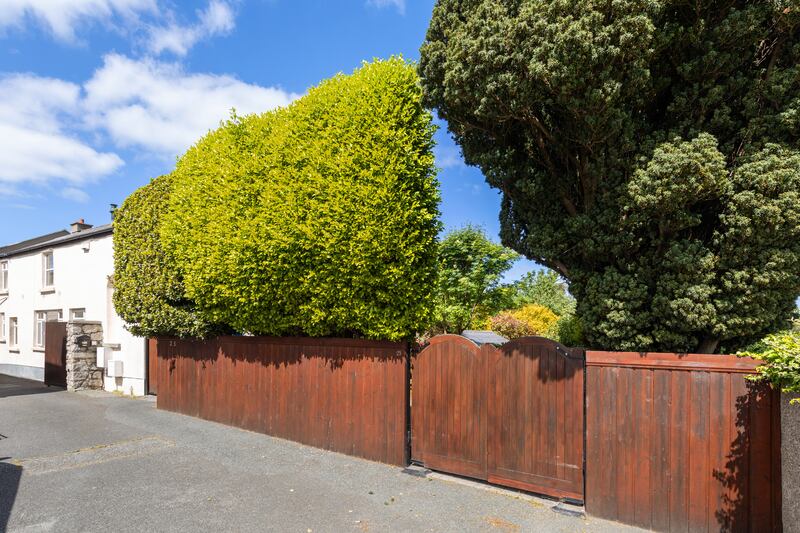 The entrance and front door is hidden behind tall hedging