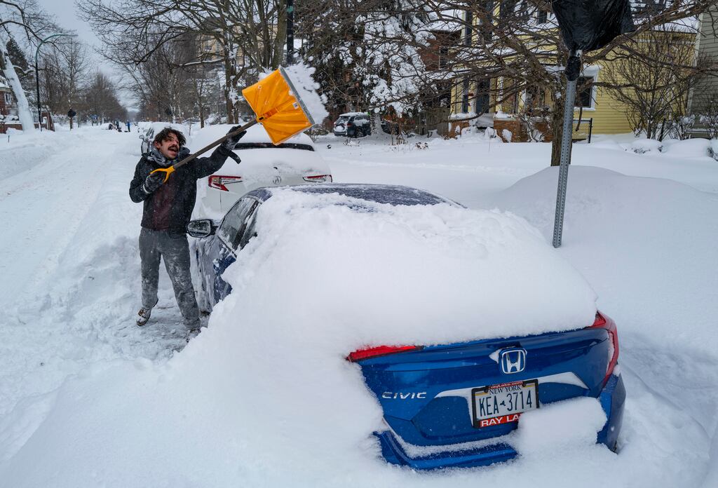 A Buffalo resident digs his car out of the snow. Photograph: Craig Ruttle/ AP