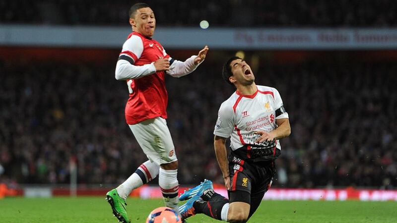 Liverpool’s Luis Suarez goes to ground after a challenge from Arsenal’s Alex Oxlade-Chamberlain at Emirates Stadium. Photograph:  Adam Davy/PA Wire