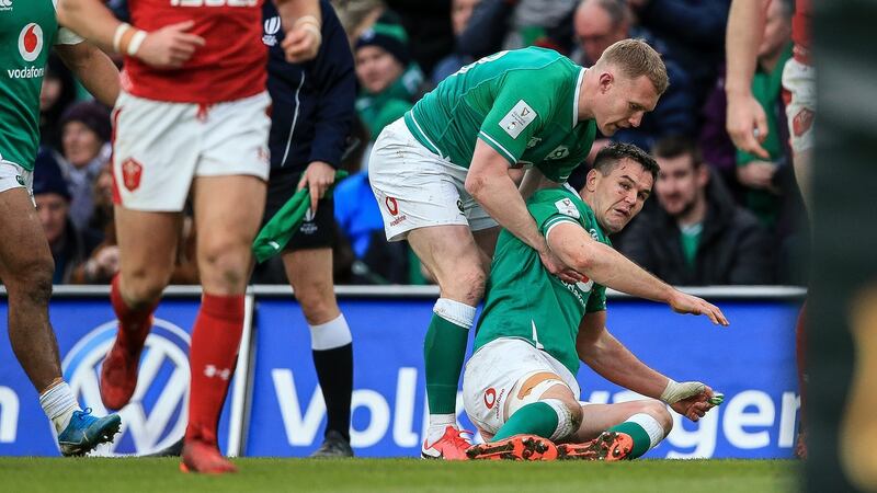 Ireland’s Keith Earls picks up Jonathan Sexton after taking a heavy knock against Wales. Photograph: Gary Carr/Inpho