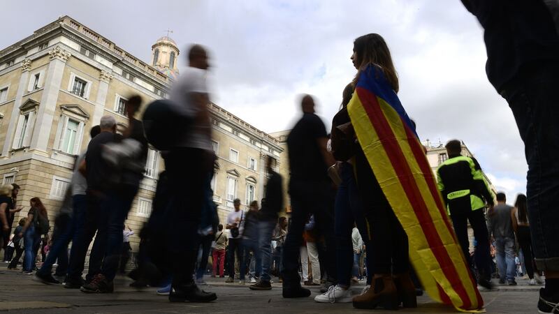 A woman wrapped with a pro-independence Estelada Catalan flag stands outside  Catalonia’s Generalitat Palace in Barcelona on Saturday. Photograph: AFP/Getty Images