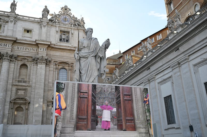 A large screen shows the master of papal liturgical ceremonies, Archbishop Diego Ravelli closing the doors of the Sistine Chapel as conclave begins to elect the next pope Photo: Antonio Masiello/Getty Images