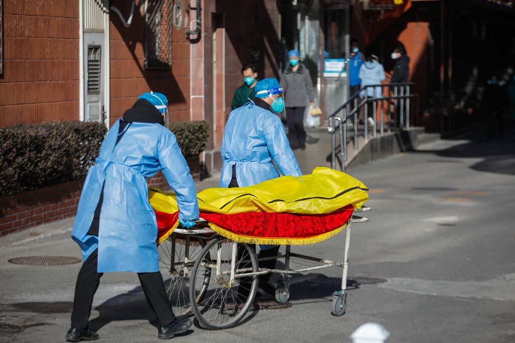 Volunteer health workers push a stretcher in front of a fever clinic at Chaoyang hospital in Beijing. Photograph: EPA