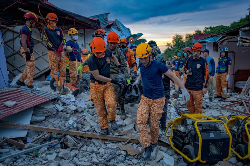 Rescue workers carry the remains of a victim following the earthquake. Photograph: Ezra Acayan/Getty Images