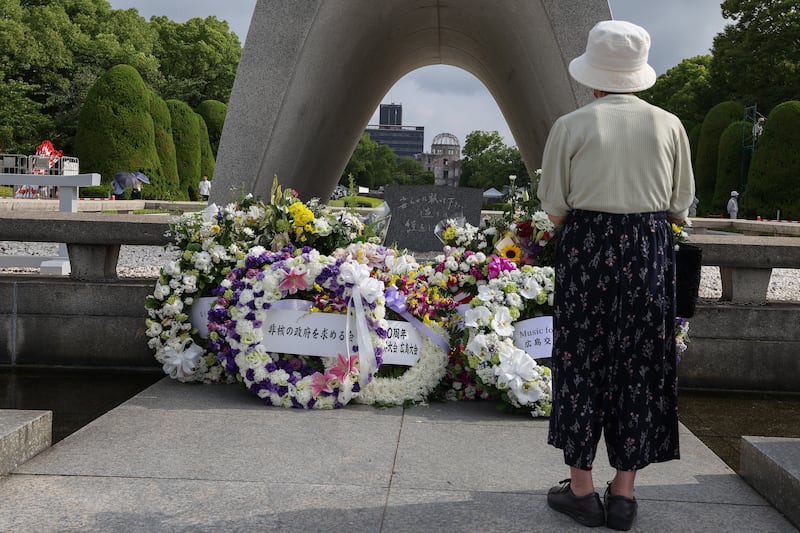 A visitor prays after offering flowers in front of the cenotaph ahead of the 80th anniversary of the atomic bomb dropped on Hiroshima at the Hiroshima Peace Memorial park on August 5th, 2025, in Hiroshima, Japan. Photograph: Buddhika Weerasinghe/Getty