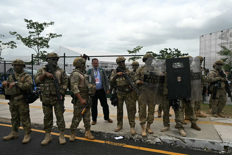 Federal police soldiers stand guard as Munduruku Indigenous people of the Ipereg Ayu movement enter an auditorium to meet Brazil's authorities during Cop30. Photograph: Mauro Pimentel/ AFP via Getty Images