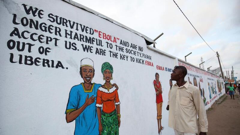 A Liberian man looks at a mural in downtown Monrovia that forms part of an Ebola awareness campaign. Liberia is one of the three countries in west Africa most affected by the worst Ebola epidemic on record. Photograph: Ahmed Jallanzo/EPA