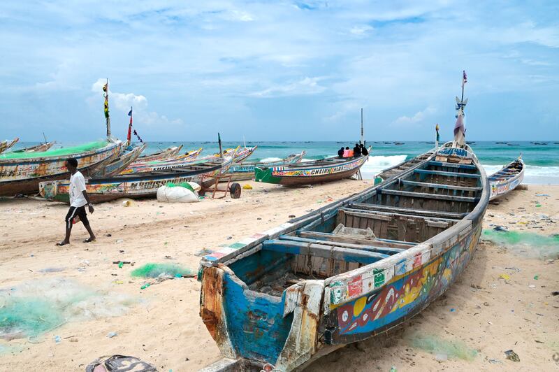 A man walks past pirogues in Fass Boye in August after one of the vessels capsized off the coast of Cape Verde. Photograph: Seyllou/Getty
