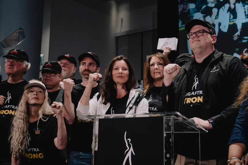 Fran Drescher, actress and president of SAG-AFTRA, raises her fist with members of the union. Photograph: Mark Abramson/The New York Times
                      
